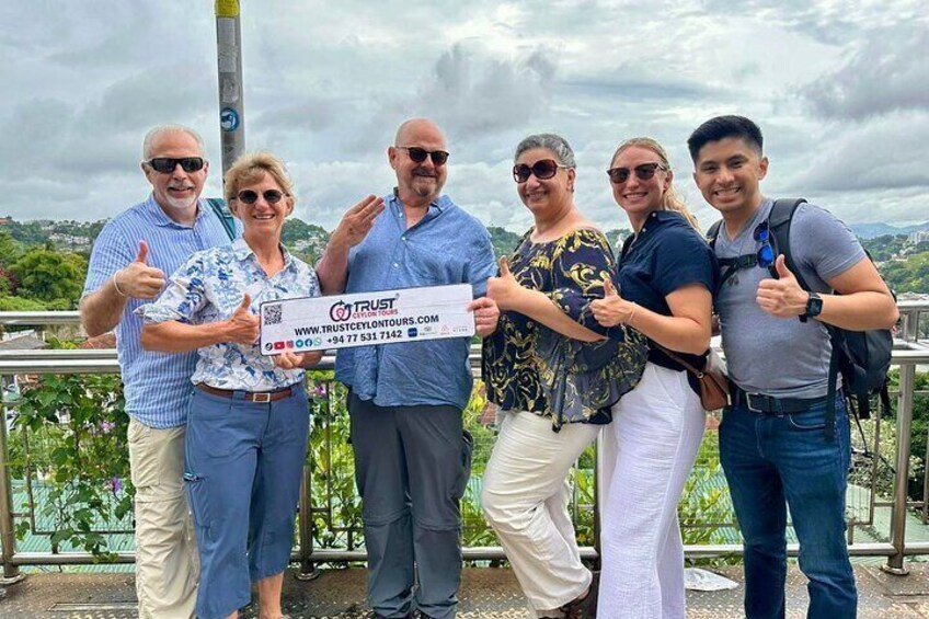 A group of people holding a large check in a scenic outdoor setting. 1