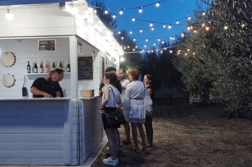 A food stall with string lights, a menu board, and a person serving. 5