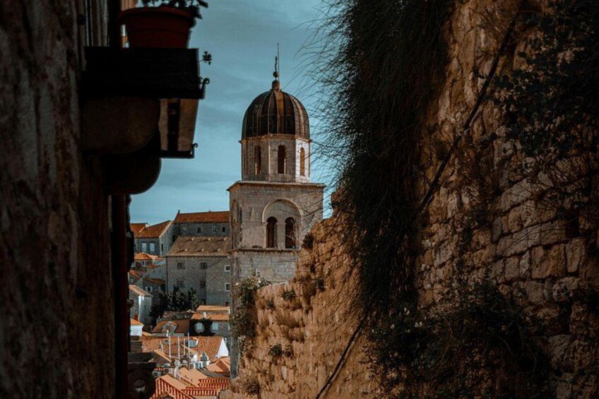 A historical building with a dome and arched windows, surrounded by stone walls and other buildings. 2