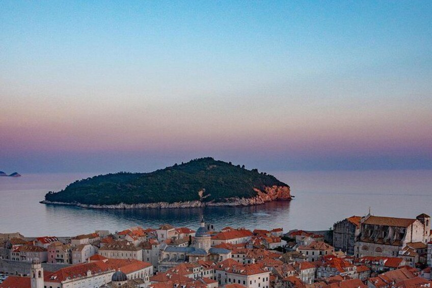 A coastal cityscape with a prominent hill and a body of water. 4