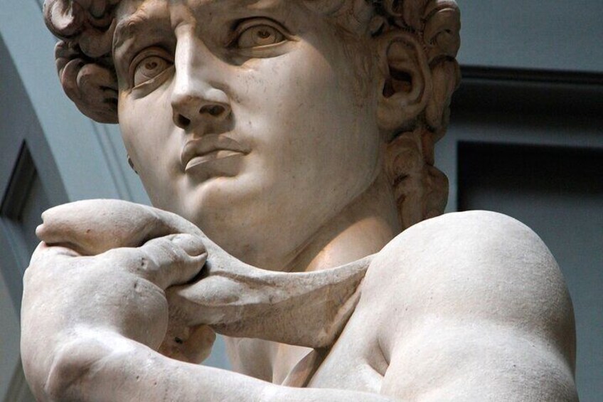 A marble statue of a bearded man with curly hair, wearing a draped garment. 1