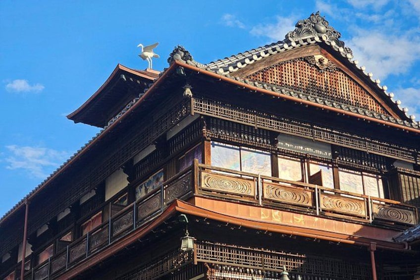 A traditional Japanese building with ornate wooden architecture, a tiled roof, and a decorative finial. 5