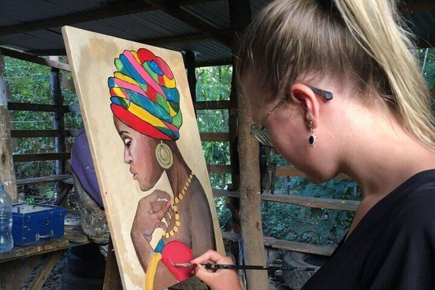 Una persona dipinge un ritratto di una donna con una sciarpa colorata. 3