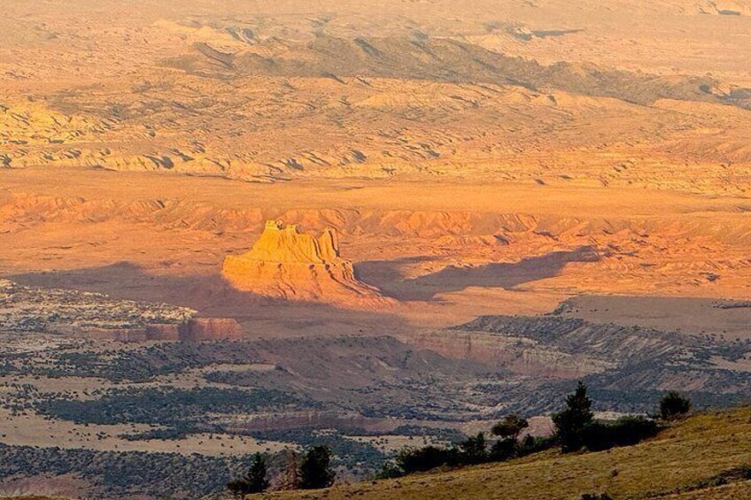 A desert landscape with a prominent rock formation in the center. 3