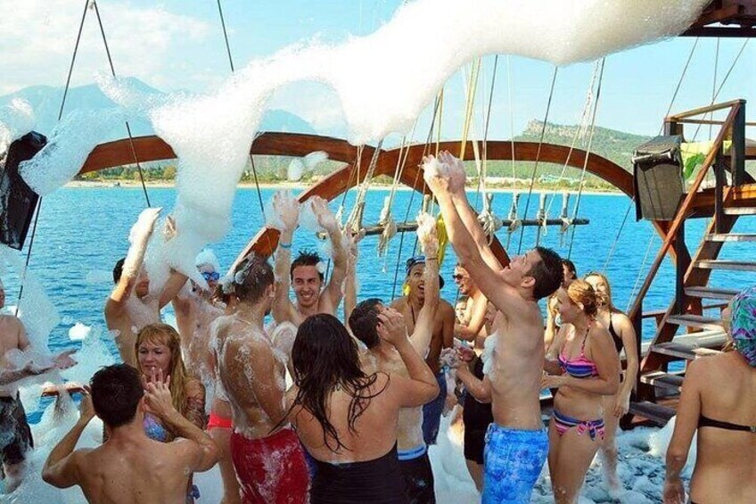 People on a boat with foam being sprayed. 4