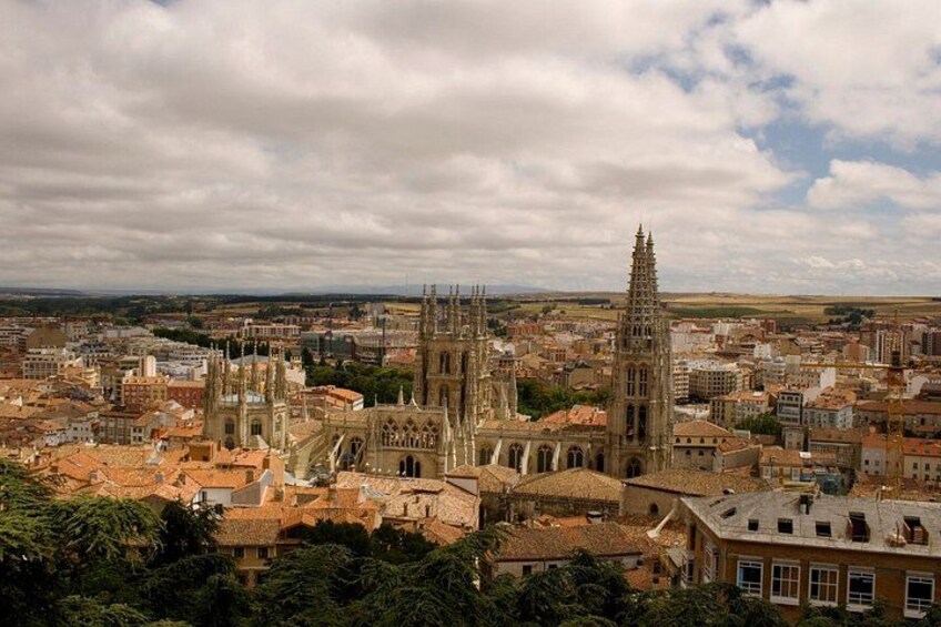 A cathedral with twin spires, surrounded by a cityscape with red-roofed buildings. 2