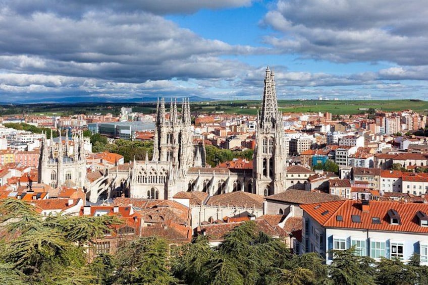 A cathedral with multiple spires, surrounded by a cityscape with red-roofed buildings. 2
