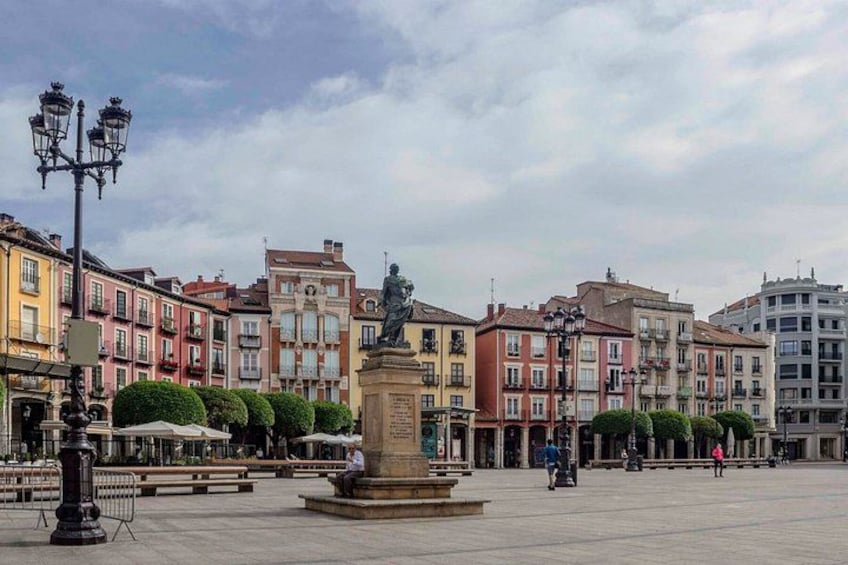 A plaza with a central statue, surrounded by colorful buildings and a clear sky. 5