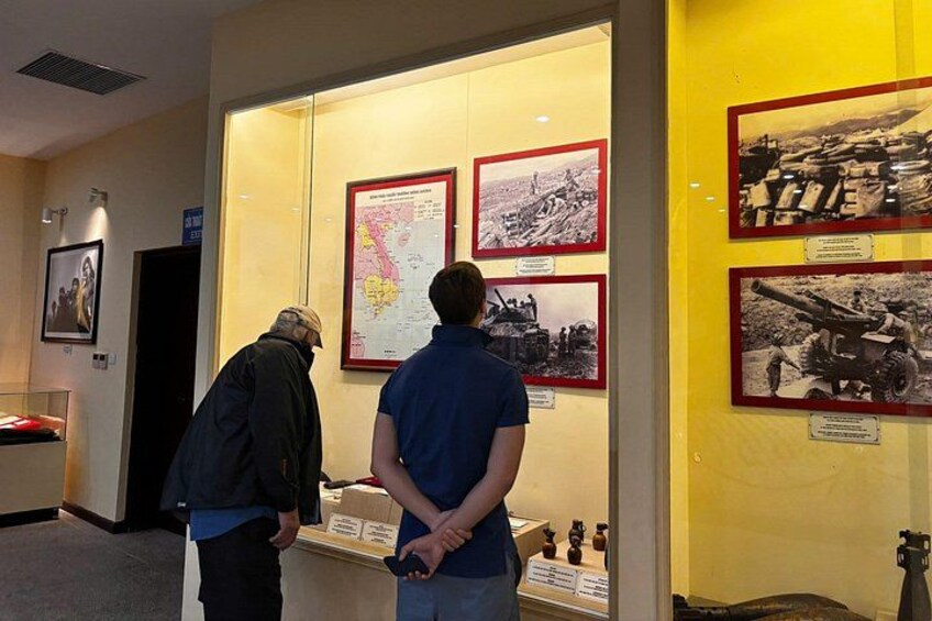Two men examining framed historical photographs in a museum. 3