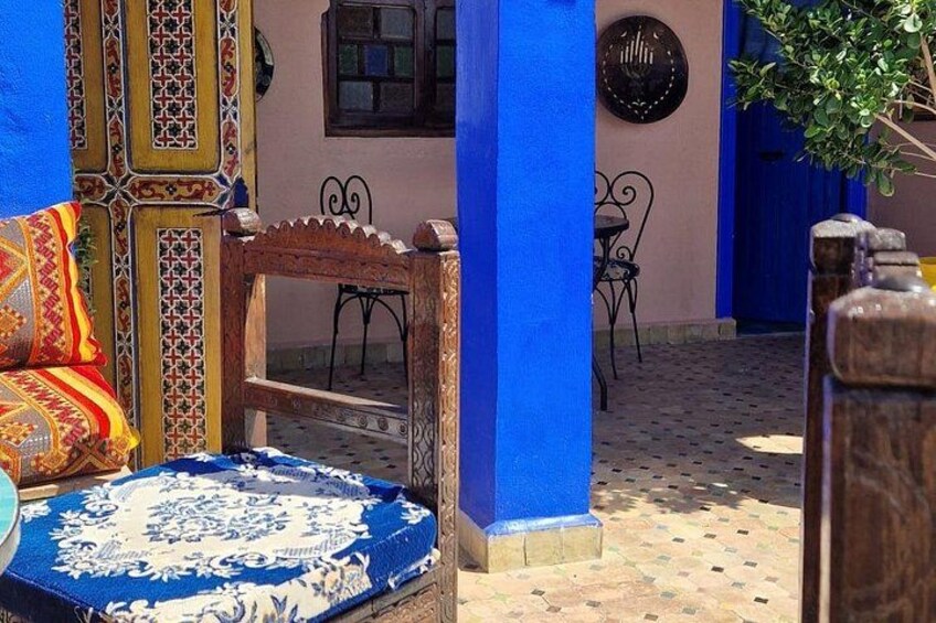 A blue and white patterned bench, a wooden chair, and a tiled floor with a geometric pattern. 5