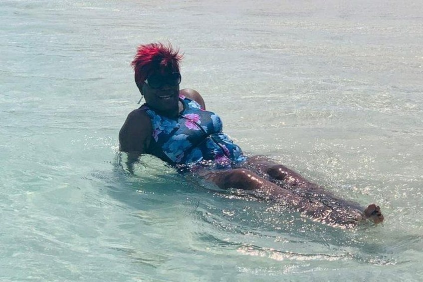 A person in a blue swimsuit floating on a body of water. 5