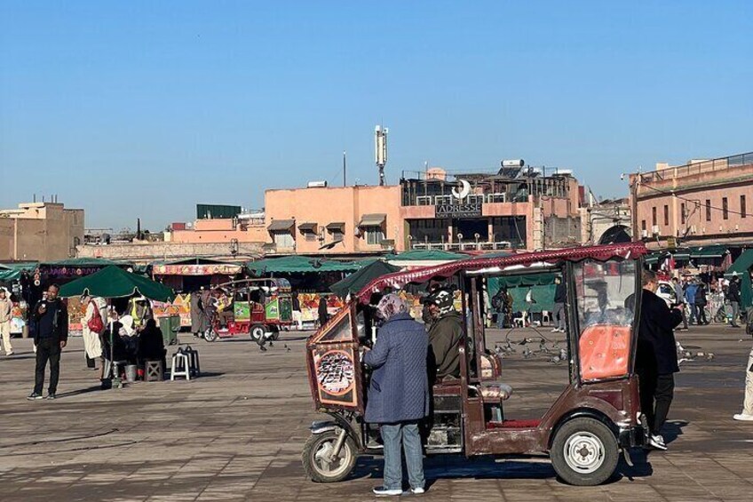 Un marché animé en plein air, avec beaucoup de monde, des étals de nourriture et une voiture ancienne. 2