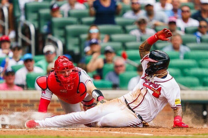 A baseball player sliding into a base while being tagged by a catcher. 5