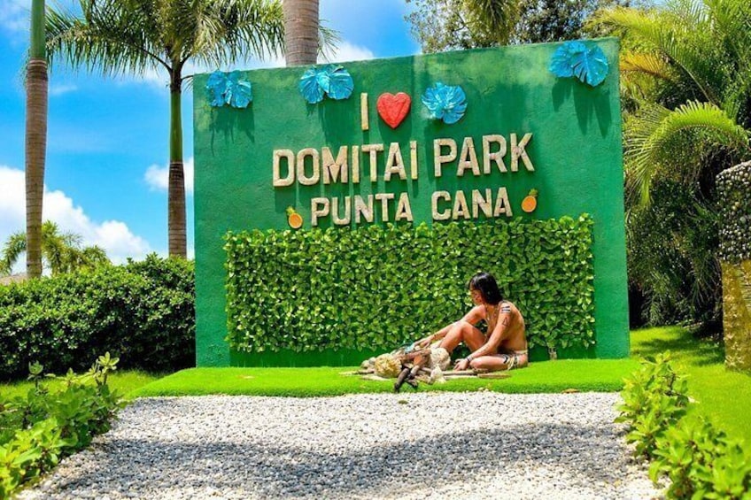 En skylt för Domitai Park i Punta Cana, med en person som sitter på marken. 3