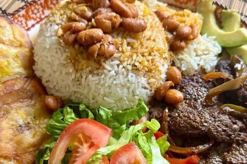Un plato de comida con arroz, cacahuates, carne y verduras. 5