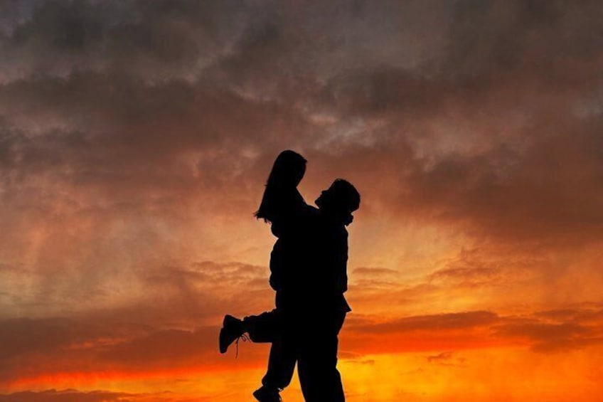 A silhouette of two people against a sunset sky. 3