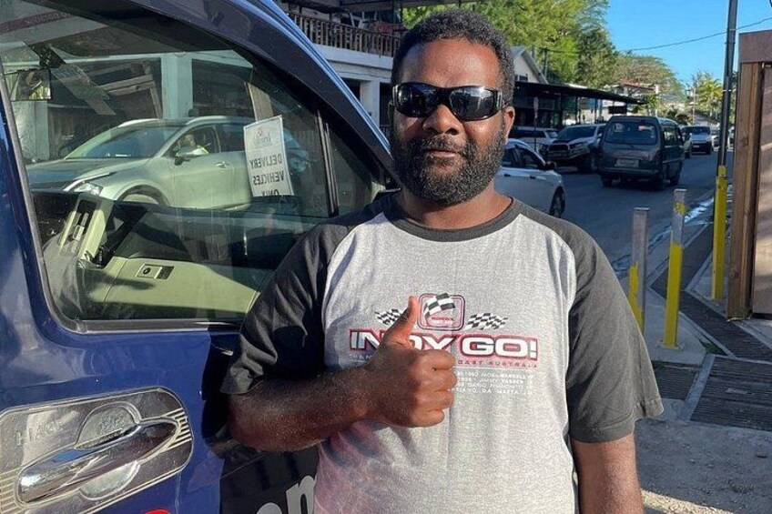 A man standing next to a car with a sign on the window. 2