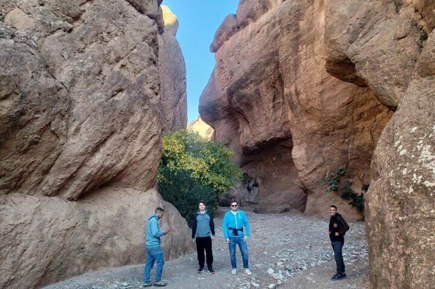 A group of people standing in a rocky canyon with large rock formations. 5