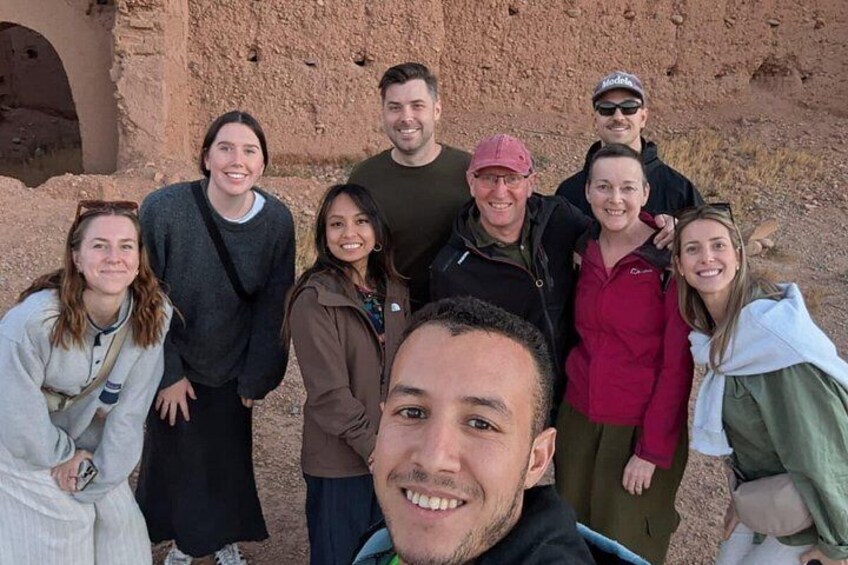 A group of people standing in front of an ancient ruin with a stone structure. 5