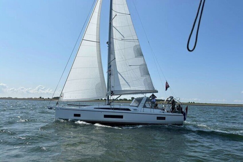 A sailboat on calm water with a clear sky. 5