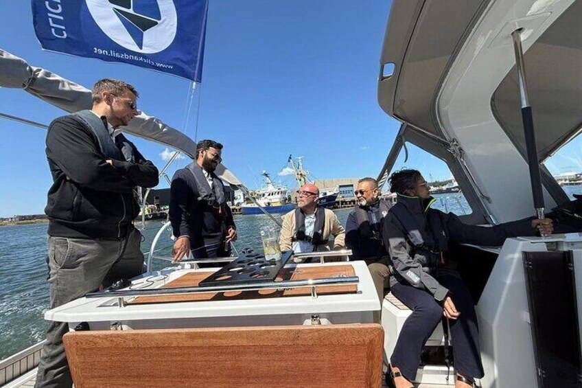 A group of people on a boat with a flag and a logo. 3