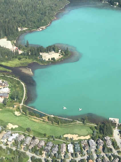 Vista aérea de un lago rodeado de bosque y zonas residenciales. 3