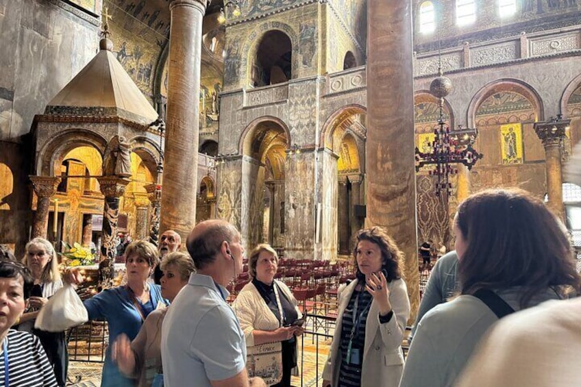 A group of people inside a large, ornately decorated church with high ceilings and detailed architecture. 1