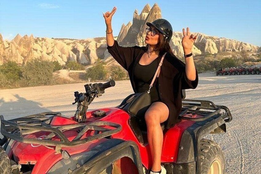 Una persona conduce un cuatrimoto rojo con un paisaje desértico al fondo. 3