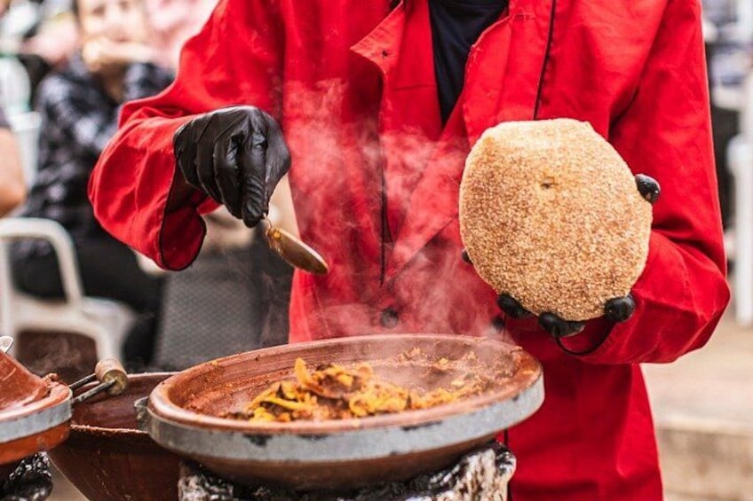 Una persona con una chaqueta roja cocinando comida en una estufa. 3