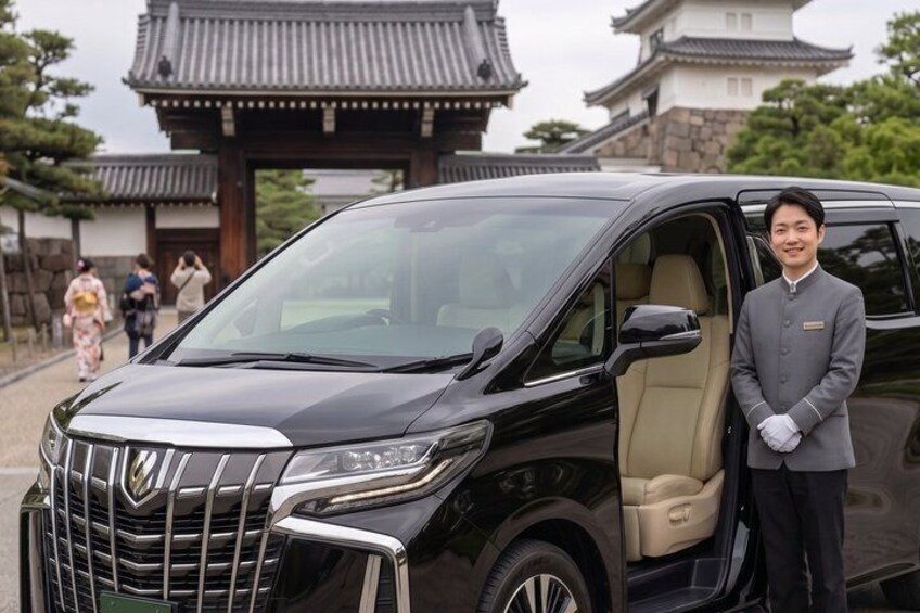 A black SUV parked in front of a traditional Japanese gate. 3