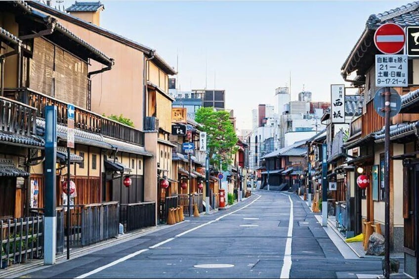 A narrow street lined with traditional buildings, a no-entry sign, and a clear sky. 3
