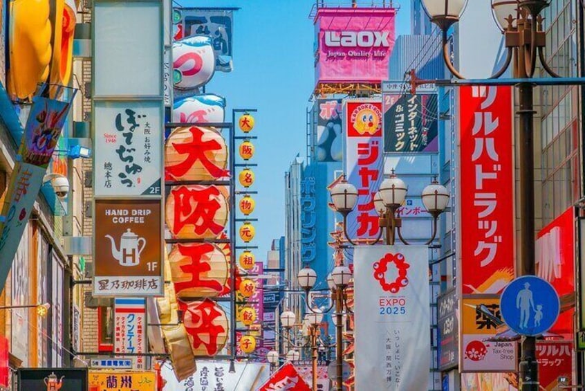 A busy urban street with numerous colorful signs and advertisements in a foreign language. 4