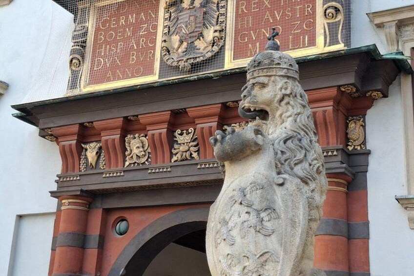 Une statue de lion en pierre, ornée d’inscriptions et surmontée d’une arche décorative. 3