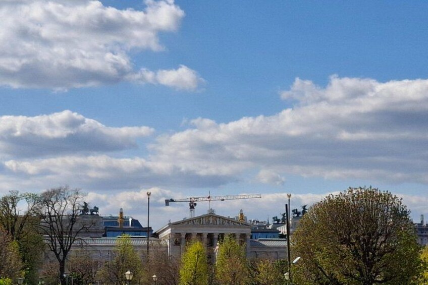 Une grue de construction, un bâtiment avec des colonnes et un ciel dégagé avec des nuages. 2