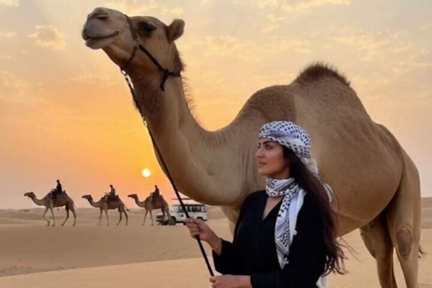 A person riding a camel in a desert with a sunset in the background. 5