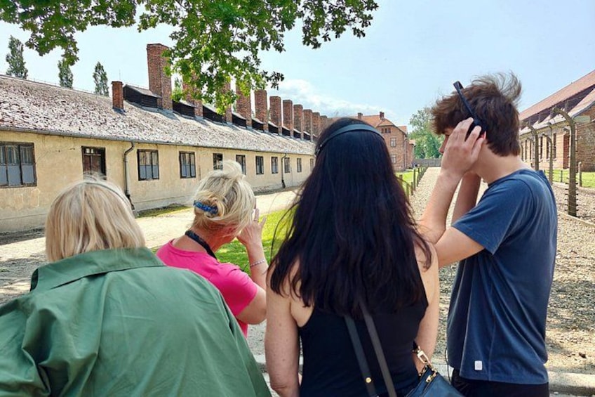 A group of people standing and looking at a historical building with brick walls and windows. 4