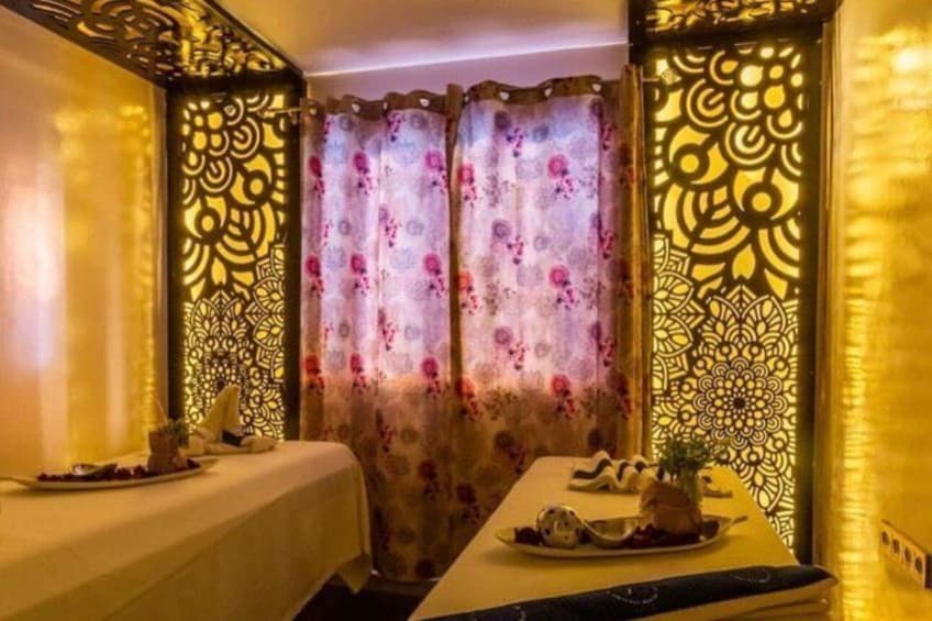 A room with a bed, a table with a vase and a plate, and curtains with floral patterns. 5