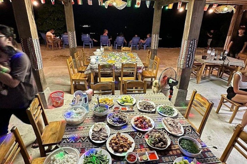 An outdoor dining area with tables set for a meal, surrounded by chairs and a covered seating area. 2