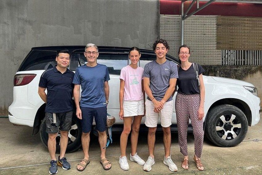 Five people standing in front of a white SUV. 5