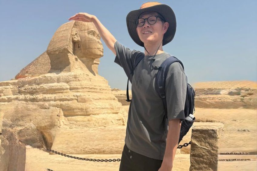 A person standing in front of the Great Sphinx of Giza. 5