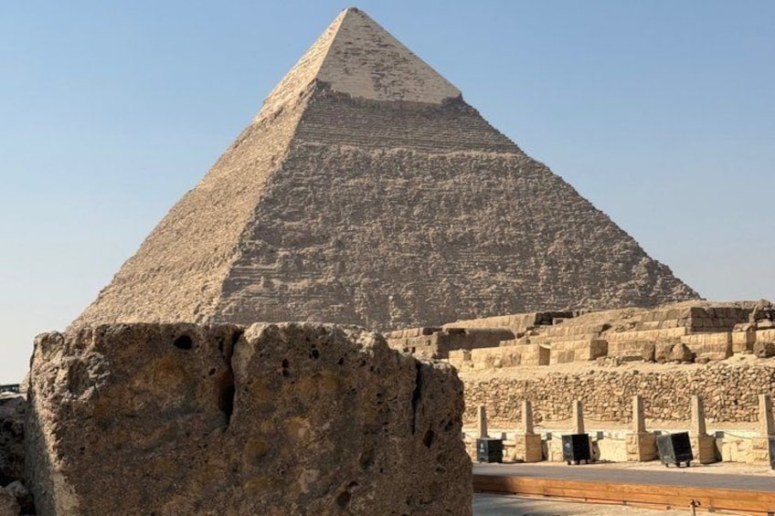 A large pyramid with a flat top, surrounded by ancient stone structures. 1