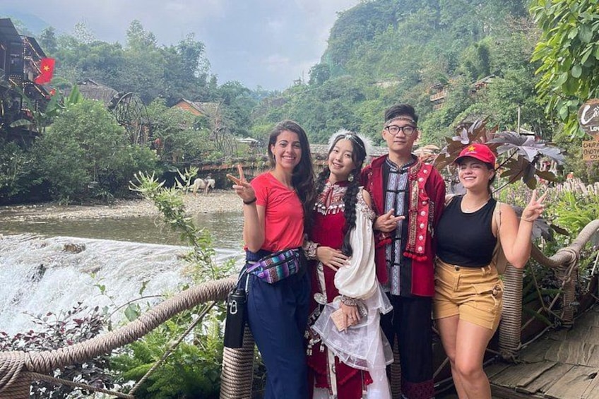 A group of people on a bridge with a river and greenery in the background. 5