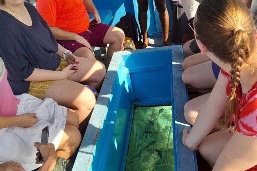 People sitting around a blue container with green writing on it. 5