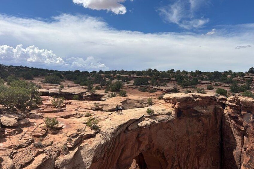 A rocky landscape with a prominent cliff and a small cave. 2