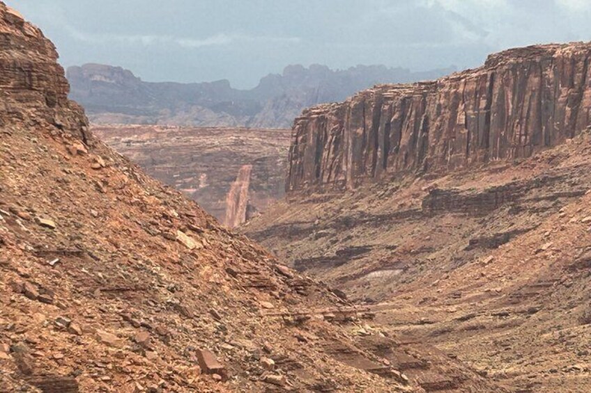 A canyon with steep rock faces and a narrow passageway. 3