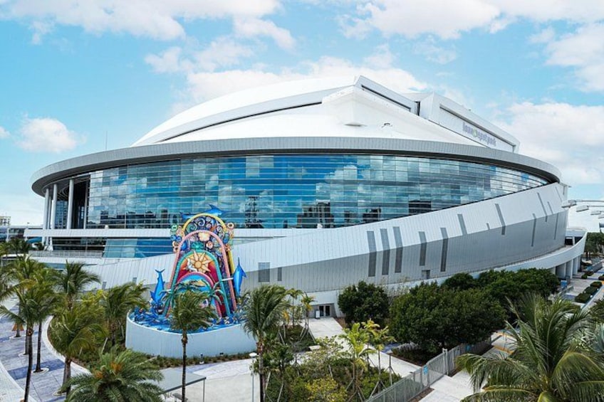 A modern building with a curved facade and a colorful sculpture in front. 3