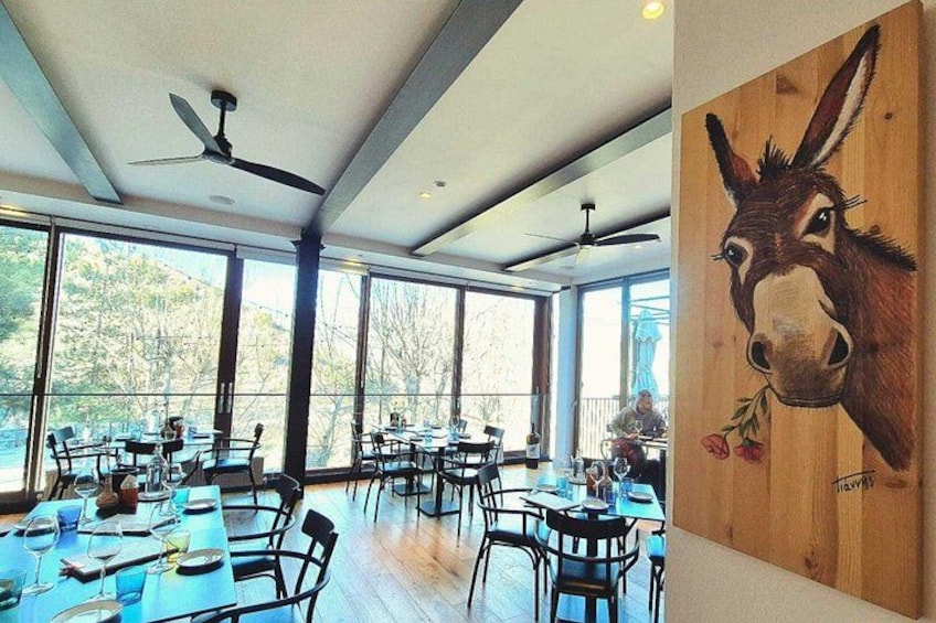 An indoor dining area with tables, chairs, and a ceiling fan. 3