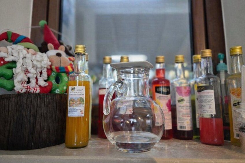 Une collection de bouteilles et un pichet en verre, posés sur une étagère. 5