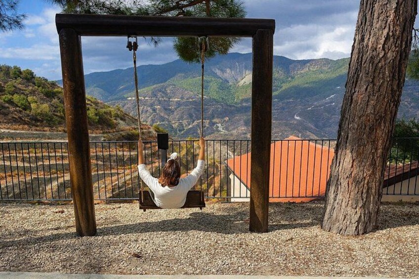 Une personne assise sur une balançoire, d’où l’on peut admirer un paysage montagneux. 3