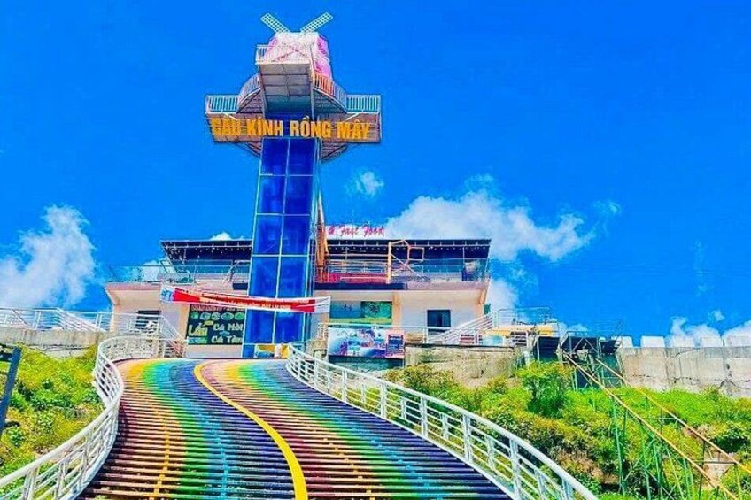 Un pont coloré mène à un bâtiment surmonté d’une tour portant l’inscription « BUIK HONG MAI ». 4